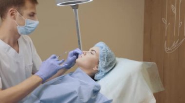 Çekici bir kız için dudak büyütme iğneleri. Estetik cerrah tıbbi klinikte dudağına iğne yapar. Kozmetik yenileme yüz tedavisi.