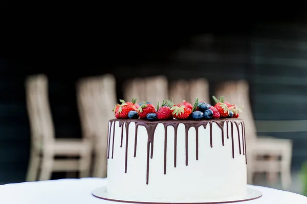 上にイチゴとブルーベリーのウェディングケーキ 儀式のための白いおいしいケーキ 料理人への広告 — ストック写真