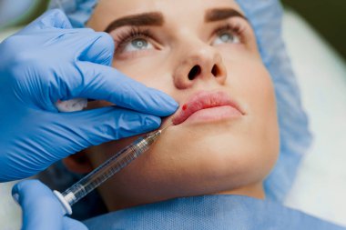 Çekici bir kız için yakın plan dudak büyütme iğneleri. Geçiş