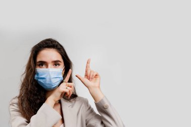 Coronavirus covid-19 karantina konsepti. Mavi maskeli çekici kız beyaz arka planda soyutlanmış olduğunu gösteriyor.