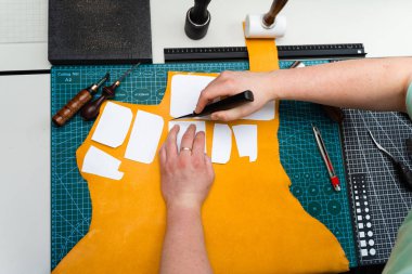 Keskin bıçak ve şablonlarla deri işçiliği. Bıçak ve şablonla deri kesimi. Esnaf kaliteli deriyi keskin bıçak ve kağıt şablonlarla keser.