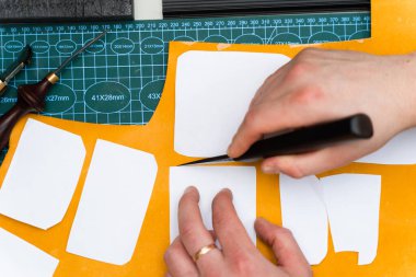 Keskin bıçak ve şablonlarla deri işçiliği. Bıçak ve şablonla deri kesimi. Esnaf kaliteli deriyi keskin bıçak ve kağıt şablonlarla keser.