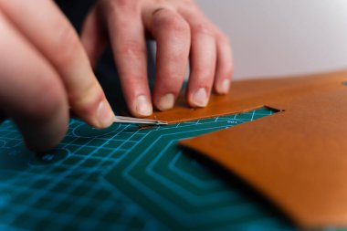 Zanaatkar deri kenarları budama aletiyle rafine eder, pürüzsüz kıvrımlar ve temiz hatlar sağlar. Deri kenarları aletle buduyorum. Zanaatkar, deri kenarları hassas bir aletle keser ve kesiği rafine eder.