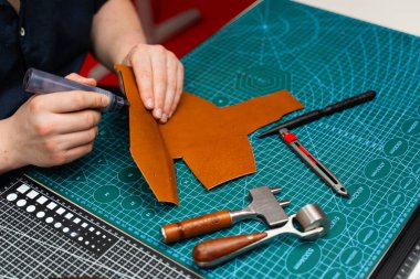 Zanaatkar koyu kenarı deri kesimine uygular, güç, pürüzsüzlük ve incelik ekler. Boyama işaretiyle bitiş çizgisinde. Esnaf deri parçasına kenar boyası sürerek dayanıklılığı arttırır.