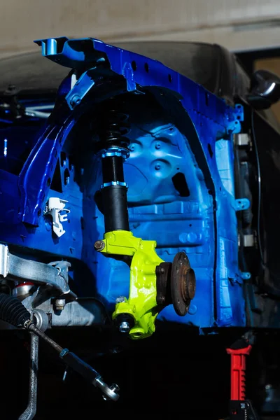 Arka süspansiyon kolları şasinin altına yerleştiriliyor. Drift Car Build için Chassis Altında Arka Süspansiyon Kurulumu. Teknisyen şasinin altındaki kol ve alt çerçeve bağlantılarını sıkılaştırır