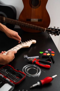 Gitar telleri köprüdeki uğursuz tuşla ayarlanır. Doğru tonlama ve konfor için. Hex Key ile Gitar Ayarlama. Gitarist köprü eyerleri ve dizgi yüksekliğini ayarlamak için bir hex anahtarı kullanır