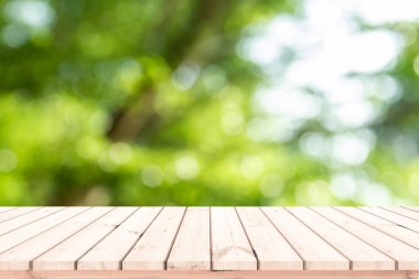 Ürün gösterimi için soyut doğal yeşil bulanık bokeh arkaplanı olan tahta kalas