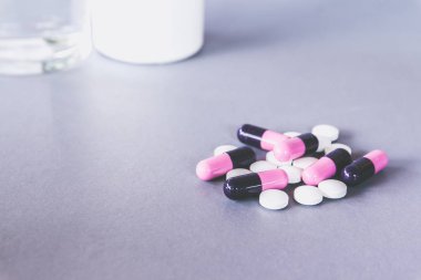 Masa üzerinde pembe siyah ve beyaz Kapsüller hapları