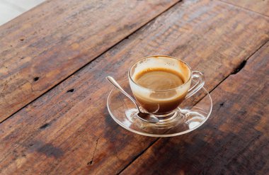 Ahşap Masa yüzeyinde cappuccino kahve ile cam kahve bardağı