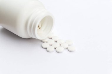 Masa yüzeyinde şişe ve beyaz haplar