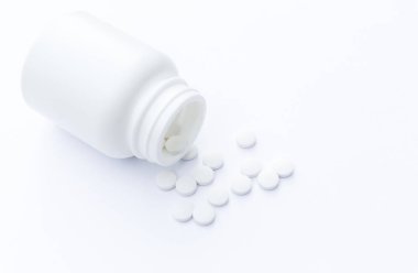 Masa yüzeyinde şişe ve beyaz haplar