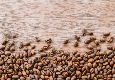 Ahşap Masa yüzeyinde kahverengi kavrulmuş kahve çekirdekleri, kopya alanı
