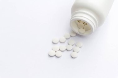 Masa yüzeyinde şişe ve beyaz haplar