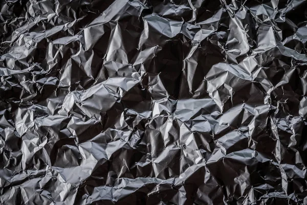 black shiny foil paper sheet background, copy space