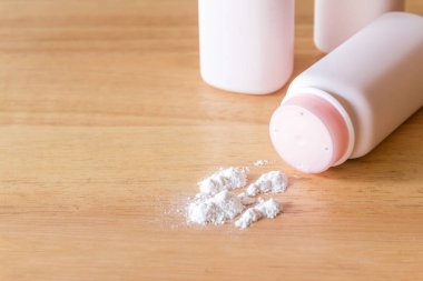 Ahşap masa yüzeyinde beyaz toz tozu olan plastik şişeler. 