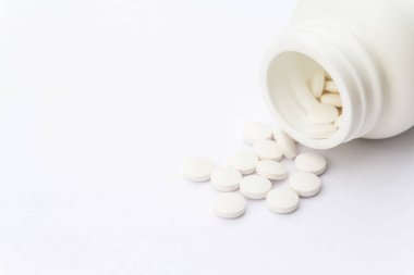 Masa yüzeyinde şişe ve beyaz haplar