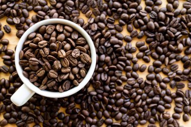 kahve çekirdekleri dolu beyaz kahve bardağı, Masa yüzeyinde tohumlar 