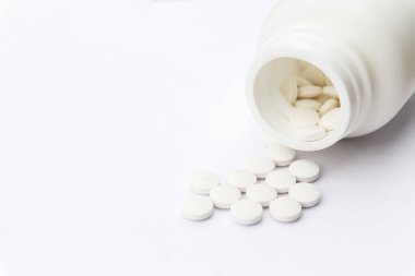 Masa yüzeyinde şişe ve beyaz haplar