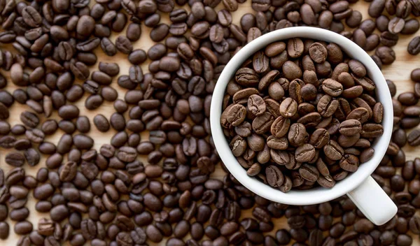 Xícara Café Branco Cheio Grãos Café Sementes Superfície Mesa — Fotografia de Stock