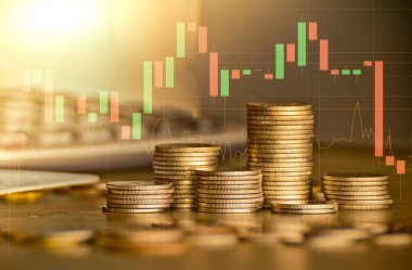 Arka planda ticaret grafiği ile altın sikke yığınları, finansal yatırım kavramı 