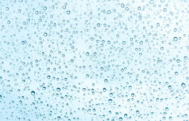 Water drops on glass on blue sky background  clipart