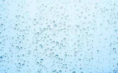 Mavi gökyüzü arka plan üzerinde cam su damlaları 