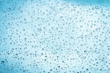 Mavi gökyüzü arka plan üzerinde cam su damlaları 