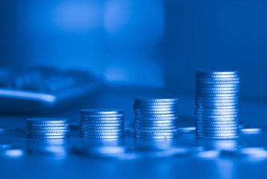 Bulanık arka planda para yığınları, para biriktirme kavramı 