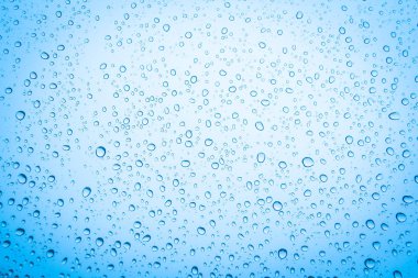 Mavi gökyüzü arka plan üzerinde cam su damlaları 