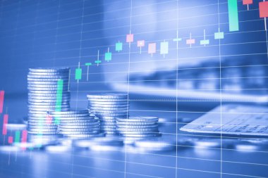 Arka planda ticaret grafiği ile altın sikke yığınları, finansal yatırım kavramı 