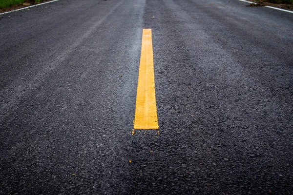 Asphalt road surface with yellow line