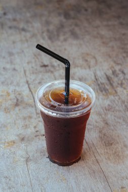 Buzlu americano sade kahvesi eski ahşap bir masada.