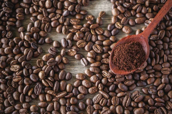 Geröstete Kaffeebohnen Und Holzlöffel Auf Altem Holzgrund — Stockfoto