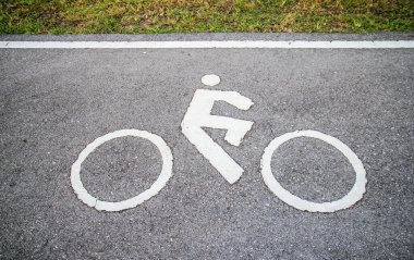 Asfalt yol arka planında bisikletçi işaret şeridi
