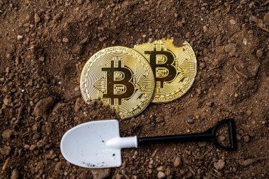 Zeminde altın bitcoin olan kürek, kripto para kavramı