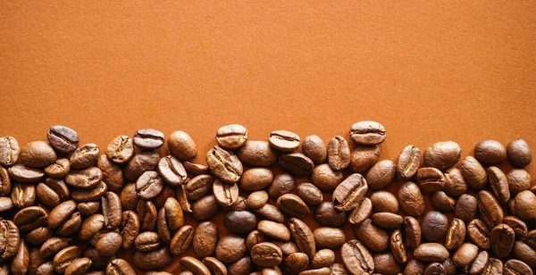 Braune Geröstete Kaffeebohnen Auf Orangefarbenem Hintergrund Ansicht Von Oben — Stockfoto