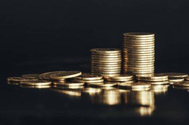 Siyah yüzeye parlak altın paralar yığılıyor