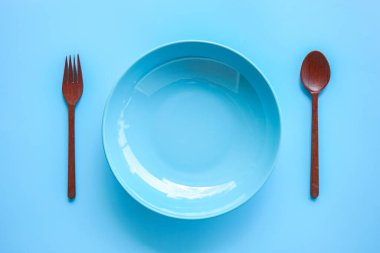 Masa mavi tabak ve çatal bıçak ile ayarlanıyor