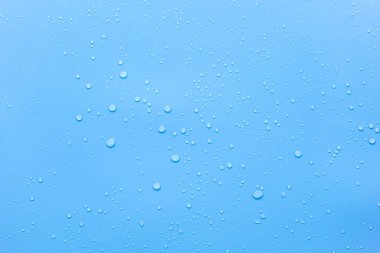 Mavi yüzeyde dinlenen damlacıklar