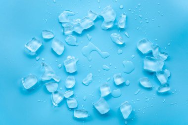 Mavi arkaplana dağılmış buz küpleri