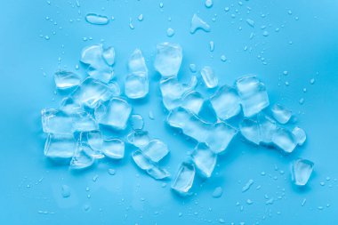 Mavi yüzeyde dağılmış buz küpleri