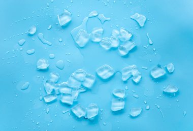 Mavi yüzeyde dağılmış buz küpleri