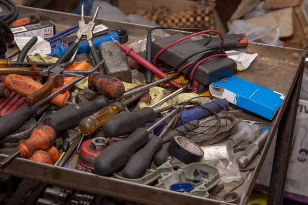 Old rusty and dirty pile of tools in the mechanic workshop. Car repairing concept with old tools.