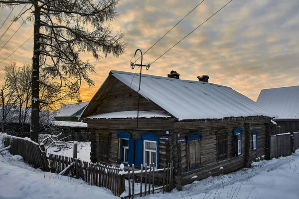Dorfhütte im Winter bei Sonnenuntergang — Stockfoto