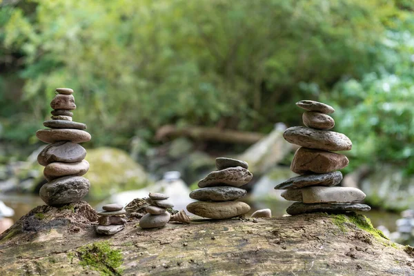 Close up of stacks of rocks on a log in a forest