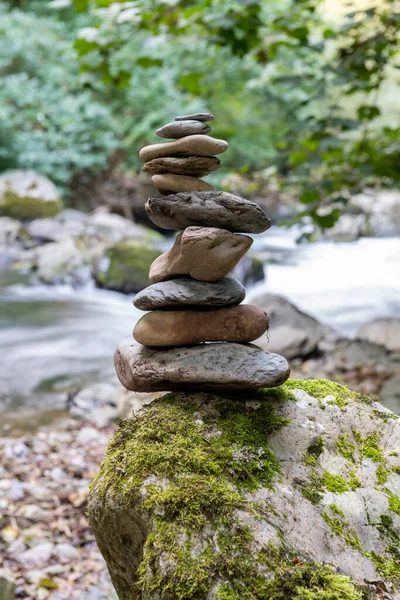 Close up of stacks of rocks on the river bank in a forest