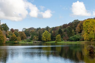 Stourton. Wiltshire. Birleşik Krallık. 26 Ekim 2024. Wiltshire 'daki Stourhead Bahçeleri' ndeki gölün sonbahar renklerinin görüntüsü.