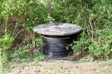 Yol kenarına bırakılmış kalın bir kablo rulosu.