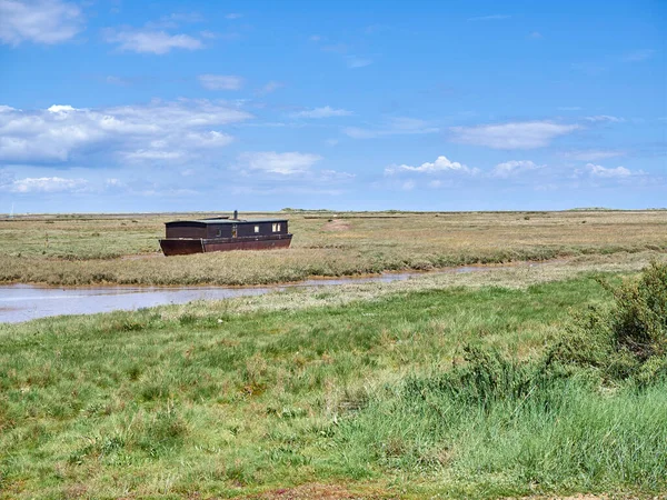 Brancaster Marsh 'taki ev teknesi, Kuzey Norfolk sahilinde Burnham Deepdale yakınlarında..
