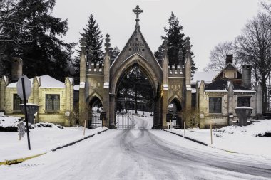Eski vintage mezarlığı gates mimarisiyle kar ve Noel çelenk Forest Hills mezarlığı Utica, New York üzerinden. Forest Hill Mezarlığı tarihi bir kayıt olduğunu.